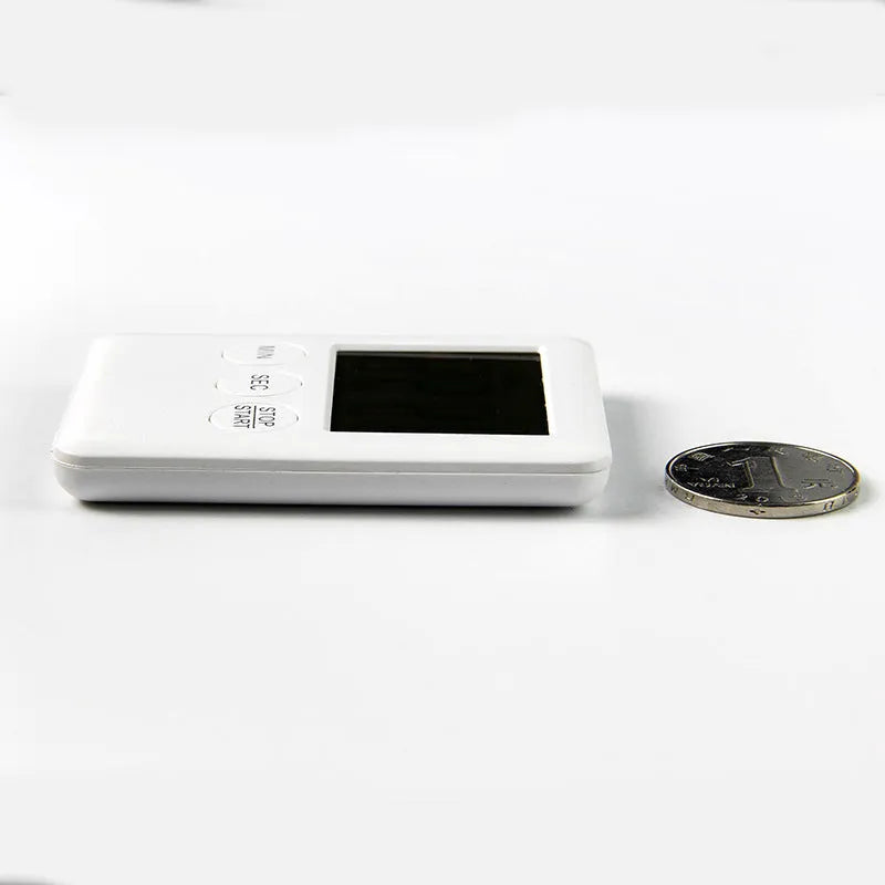 Black and white magnetic kitchen timer with countdown and count-up display on a refrigerator.