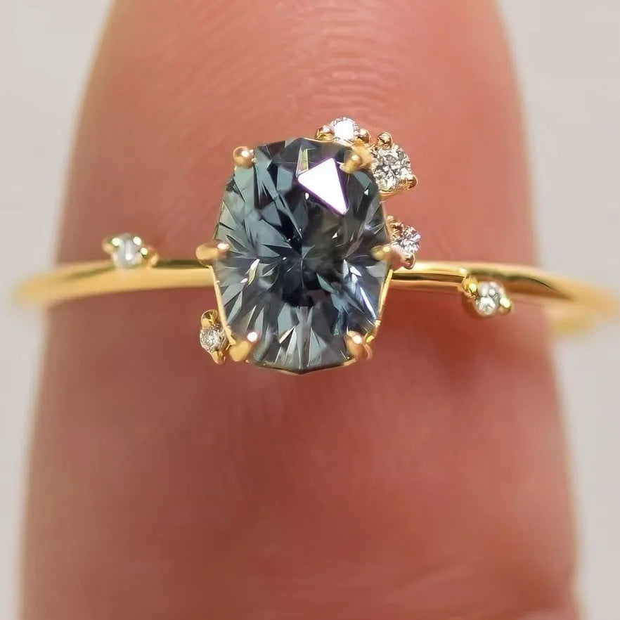 Gold plated women's ring with green zircon stone in flower-shaped design on finger