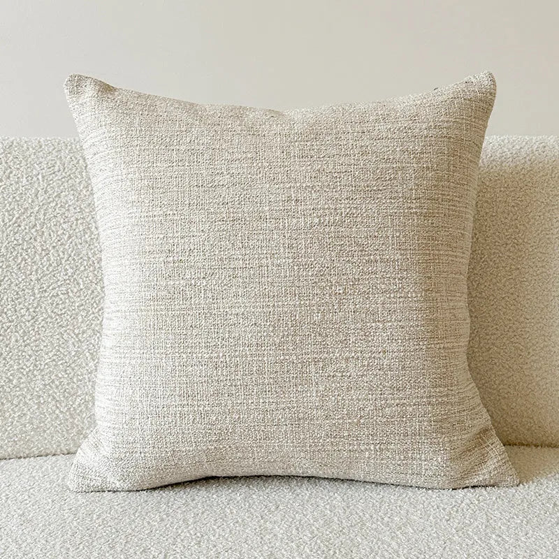 American-style jacquard pillow cover with paisley and flower pattern in amber colour, shown on a sofa.