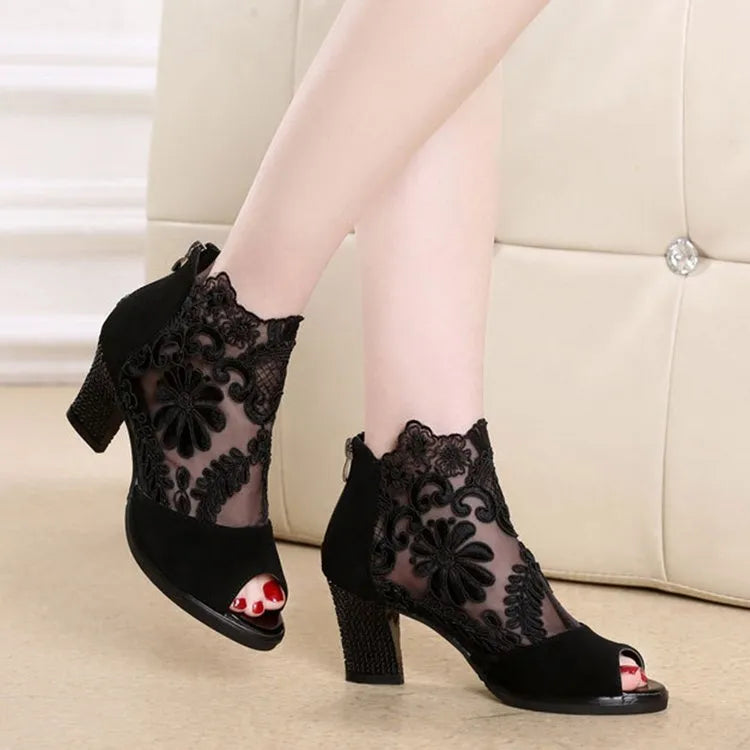 Women's black lace gladiator sandals with square high heel and zip closure, showing flower pattern detail