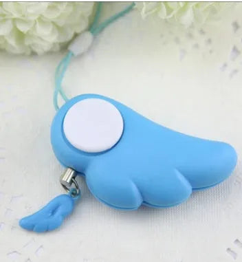 Blue personal security alarm with clip attached to a handbag strap, showing compact size and pull-rope mechanism