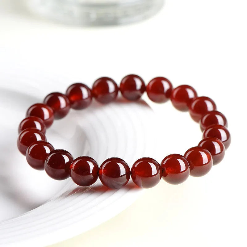 Natural orange red garnet ball crystal bracelet with traditional ruyi design elements on wrist