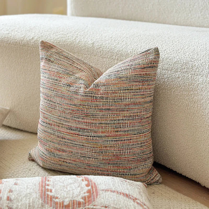 American-style jacquard pillow cover with paisley and flower pattern in amber colour, shown on a sofa.