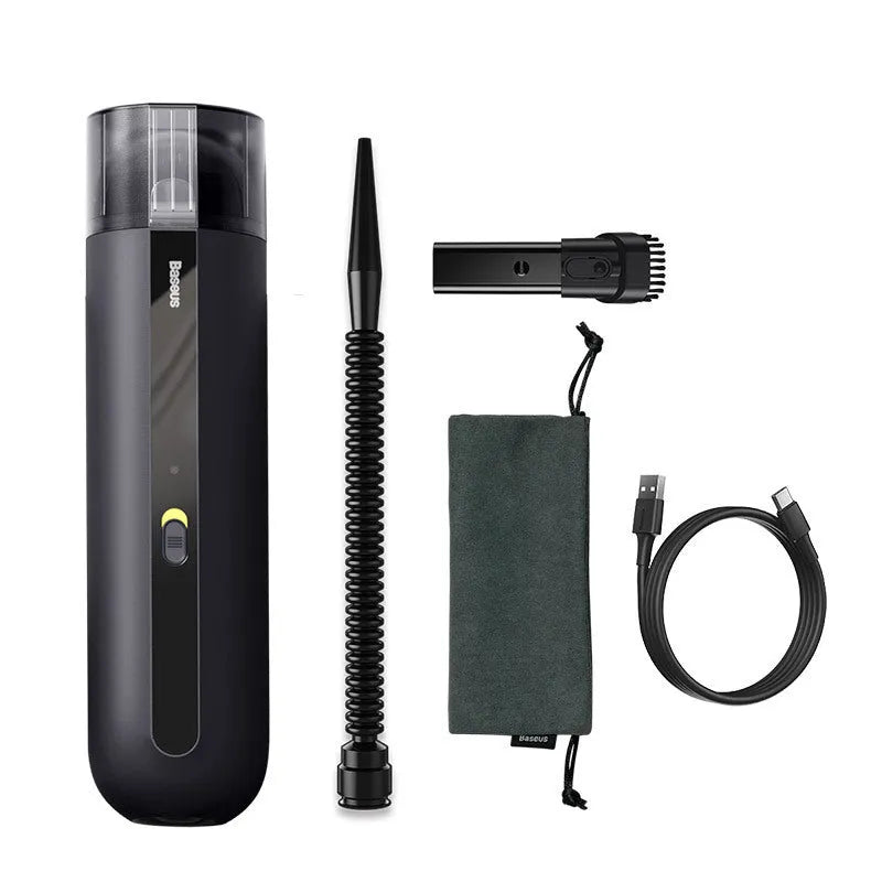 Black cordless handheld car vacuum cleaner with blowing hose attachment on a desktop.