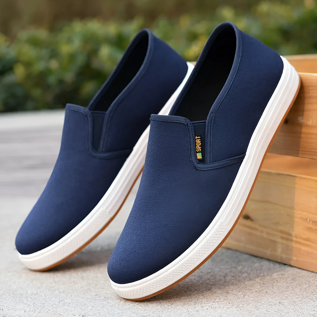 Men's black and blue slip-on canvas shoes with composite soles showing round toe design