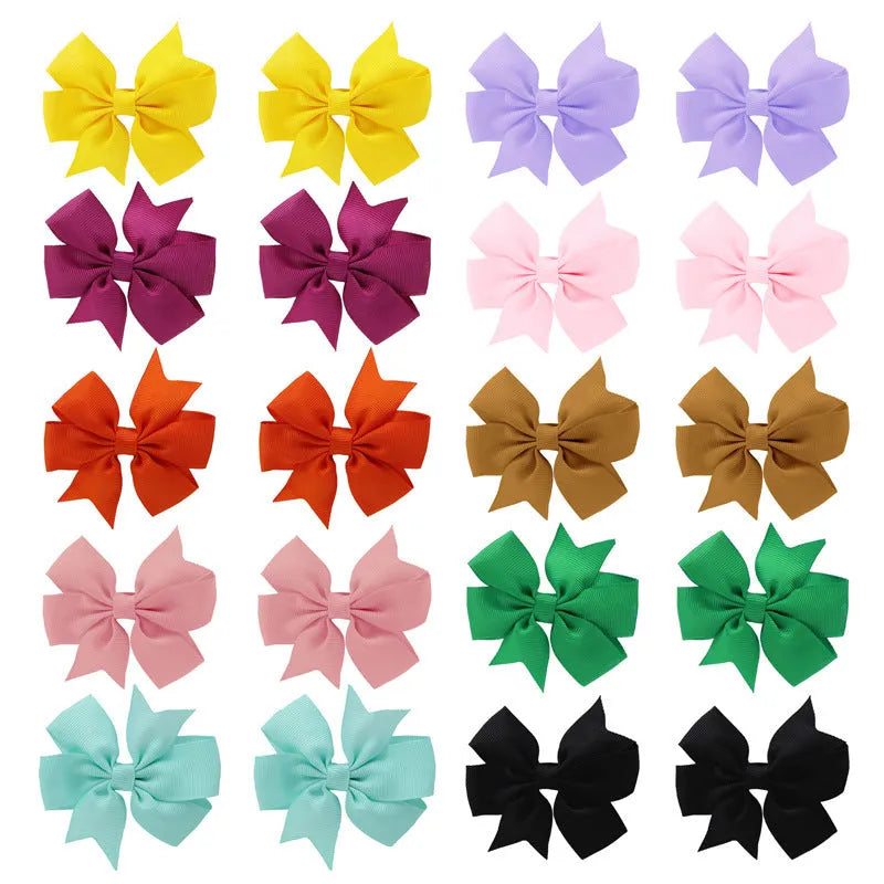 Assortment of multicoloured 3 inch grosgrain ribbon pinwheel hair bows with alligator clips for toddlers.