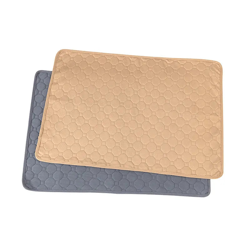 Grey and khaki washable waterproof dog pee pad on a wooden floor next to a pet crate.