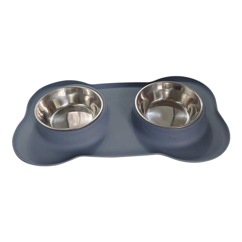 Large silicone double dog bowl in blue with two compartments for food and water on a kitchen floor.