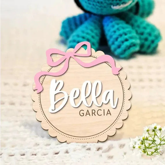 Customised square wooden baby room ornament with a personal name, shown in two size options.