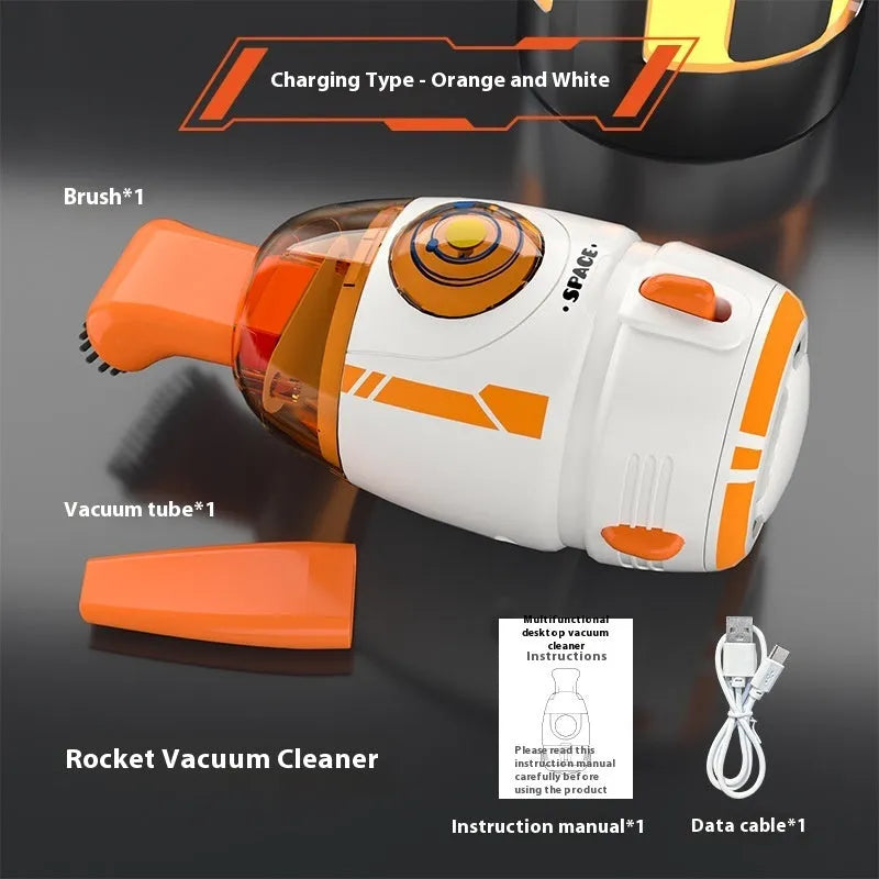 Handheld desktop vacuum cleaner in blue rocket design with USB charging cable on a wooden desk.