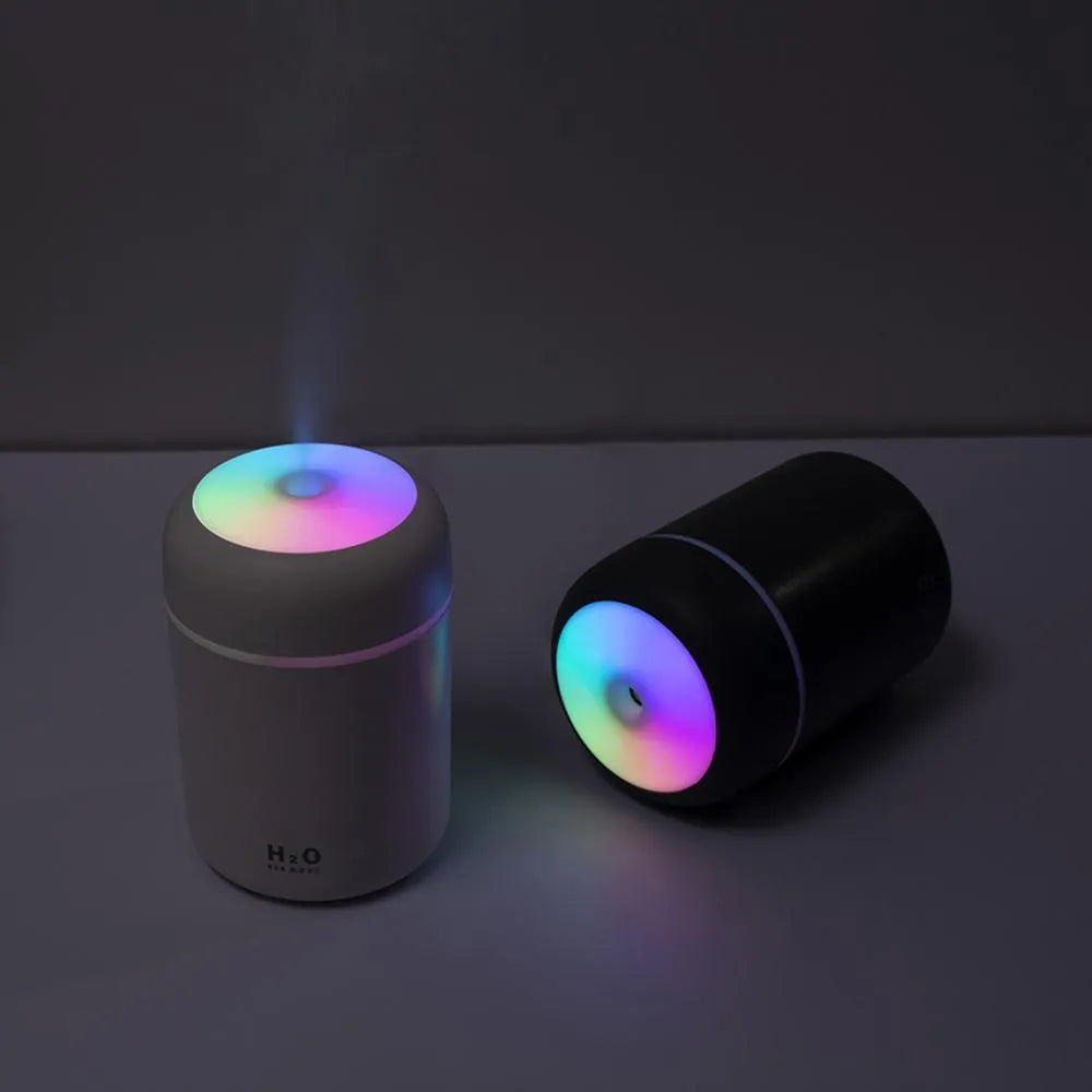 Pink USB desktop humidifier with colourful LED lights and 300ml water tank on wooden desk