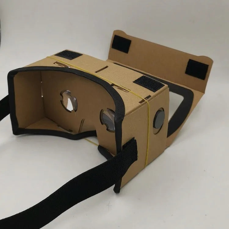 Pink and white cardboard VR glasses for smartphones, shown with 3D lenses and a rubber headband.