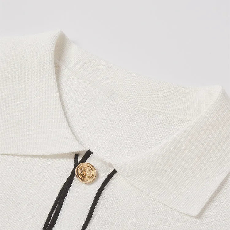 White women's short sleeve cardigan with dark contrast colour lapels on a hanger.