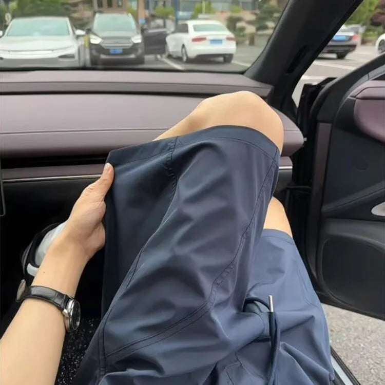 Men's quick-drying polyester sports shorts in straight cut with elastic waist, fifth pants length