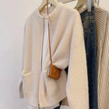 Beige women's long sleeve soft glutinous sweater coat cardigan laid flat.