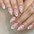 Short almond-shaped false nails with glossy French tip and glitter flower decoration, colour C625.