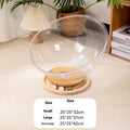 Transparent acrylic space capsule-shaped cat bed or enclosure on a turntable base.