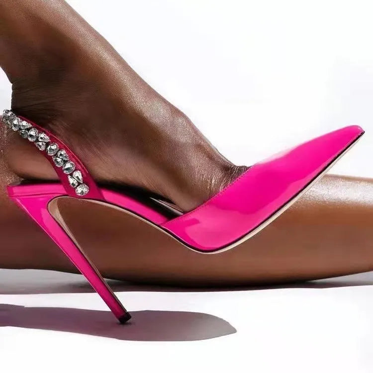 Women's patent leather high heel sandals with pointed toe, clear ankle strap, and rhinestone details.