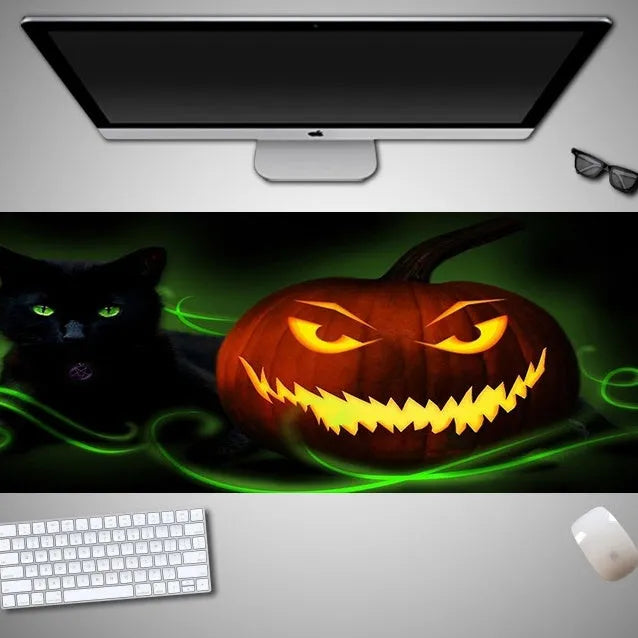 Oversized Halloween graphic cloth mouse pad on a desk, showing non-slip rubber base.