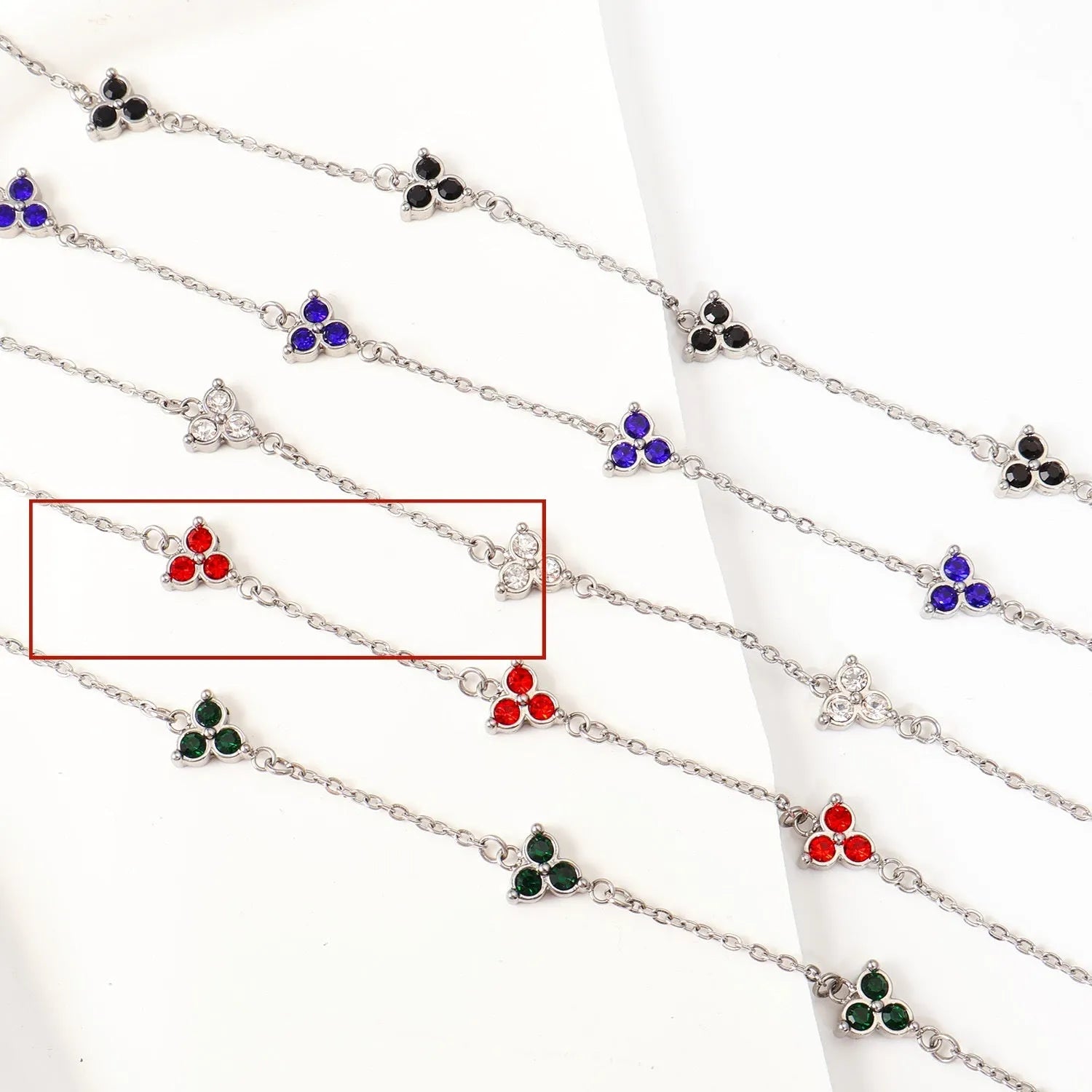Women's stainless steel geometric bracelet with triangle design and three-diamond centrepiece in gold or steel finish.