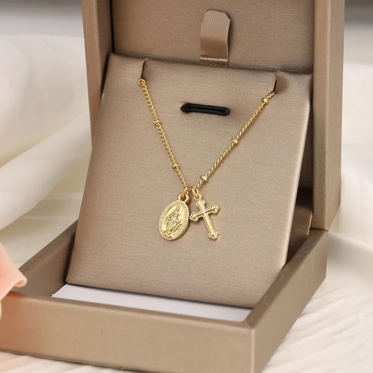 Geometric Cross Virgin Mary pendant necklace in gold on a simple chain.