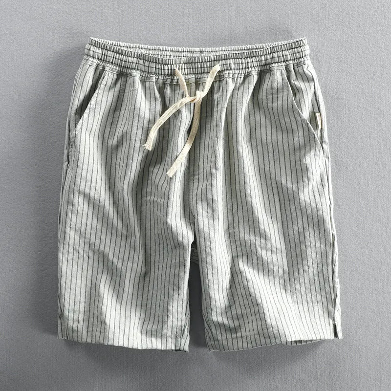 Man wearing black and white striped loose-fit casual cotton shorts with a mid waist.