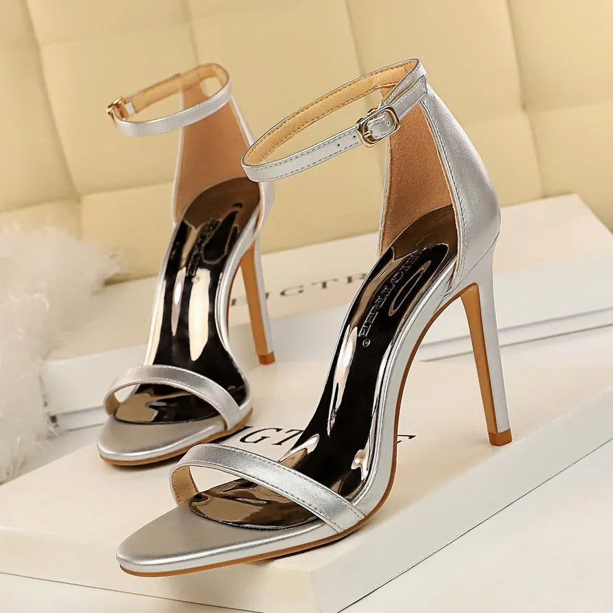 Women's ankle-strap high heel sandal in black with open toe and silver buckle.