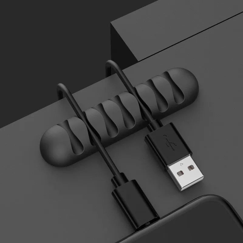 Smart cable holder with TPR flexible clips in black holding USB earphone and network cables on a desk