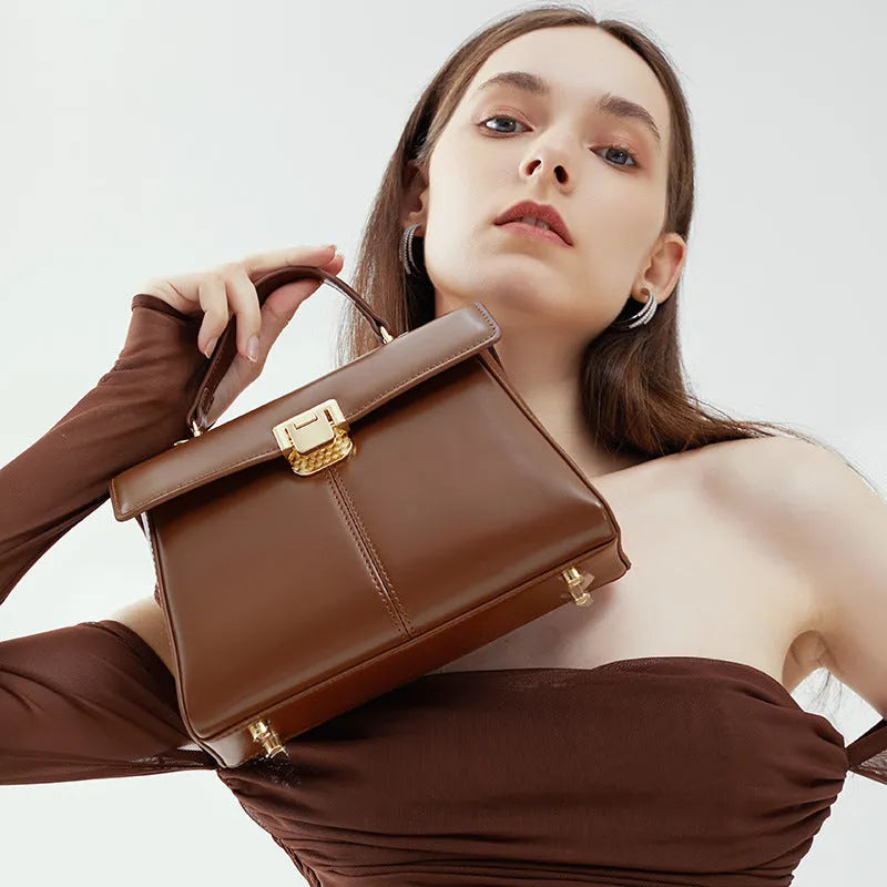 Women's black leather shoulder bag with vachette clasp showing internal compartments and adjustable strap