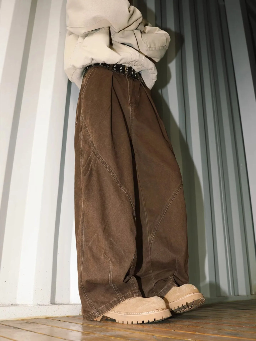 Men's pleated straight-leg trousers in apricot colour on a hanger
