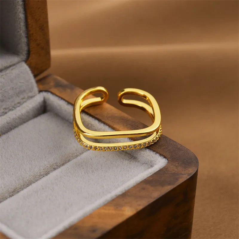 Gold geometric open ring for women on a grey background.