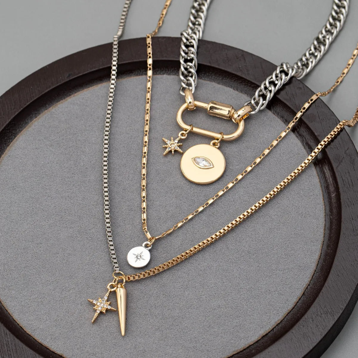 Alloy multi-layer twin necklace with geometric elliptical pendant on a white background
