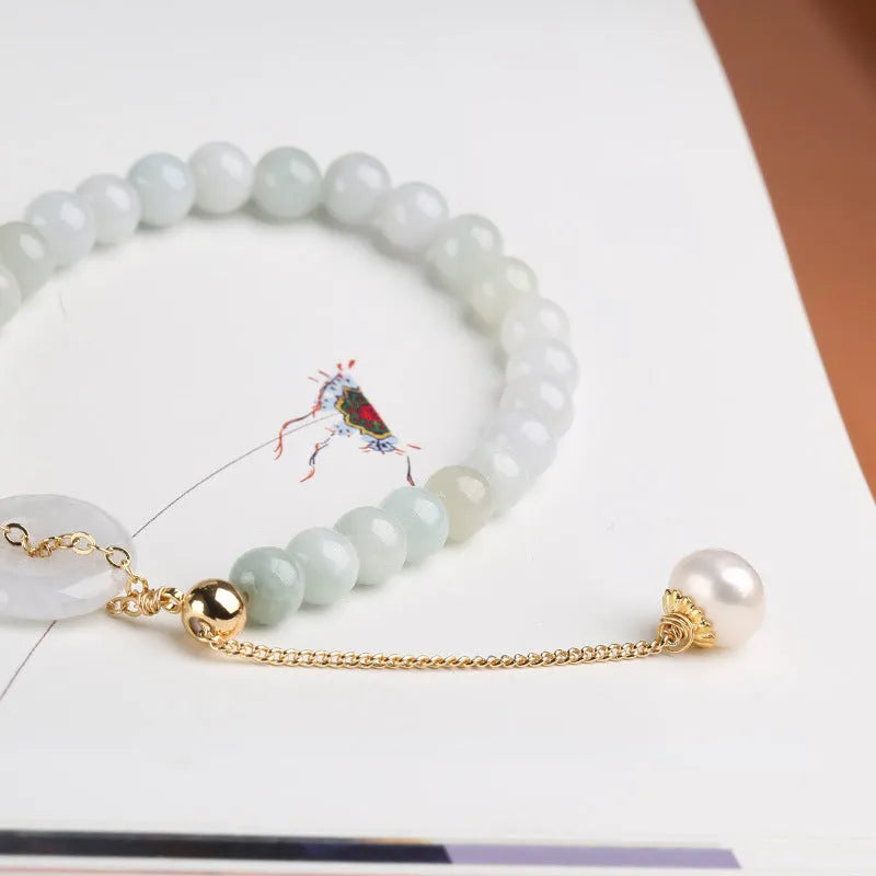 Jade green bracelet with peace buckle fastener and round pearl charms on wrist
