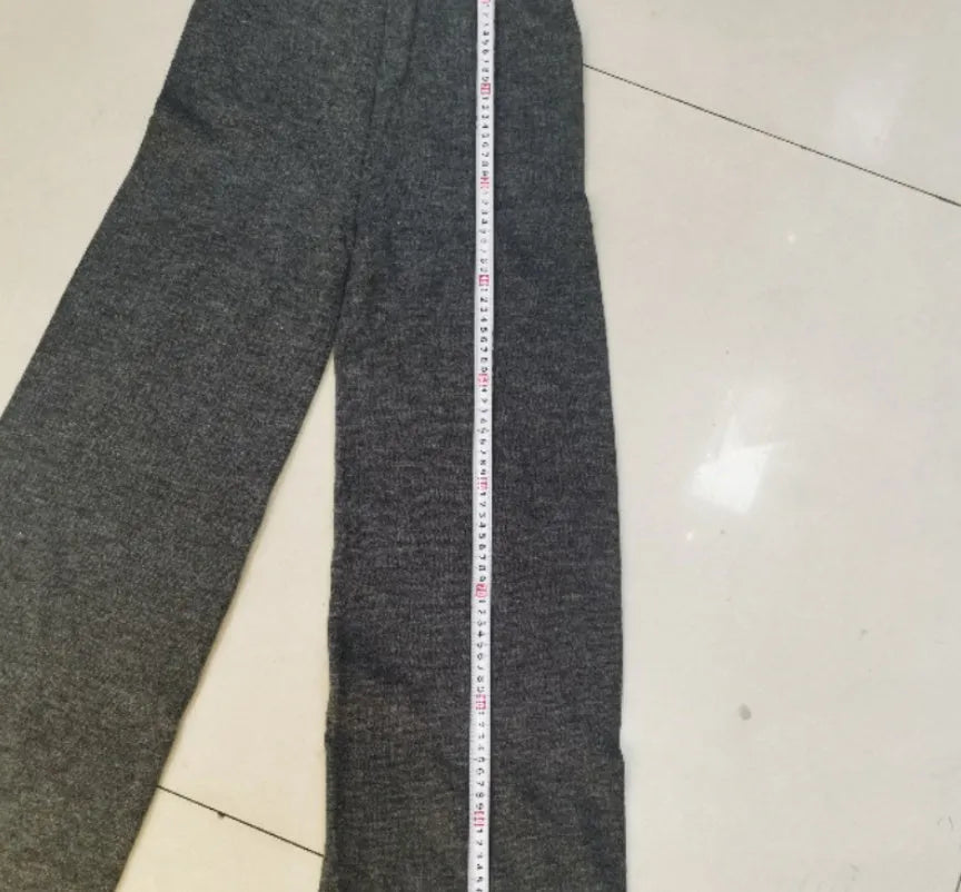 Women's knitted acrylic suit set with side-slit top and matching trousers in a solid colour.