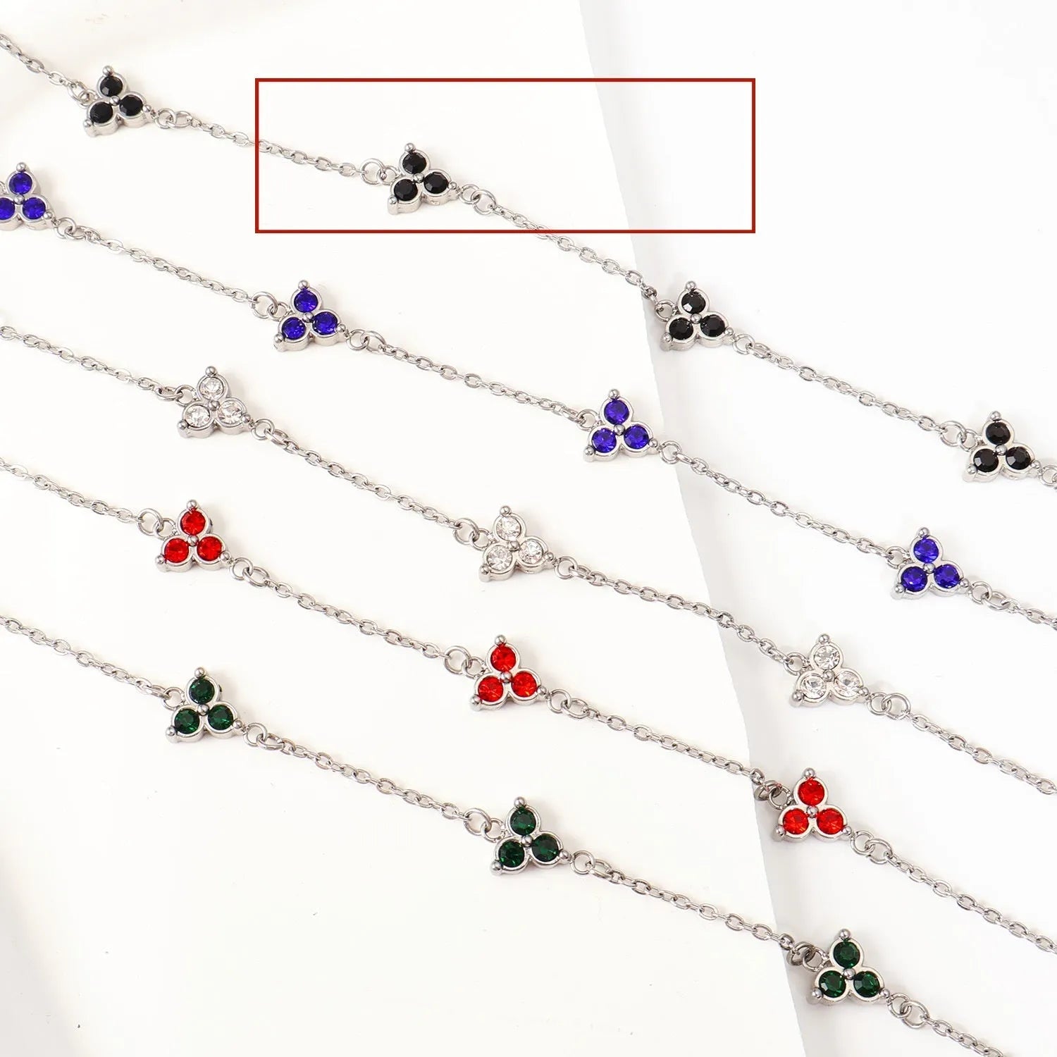 Women's stainless steel geometric bracelet with triangle design and three-diamond centrepiece in gold or steel finish.