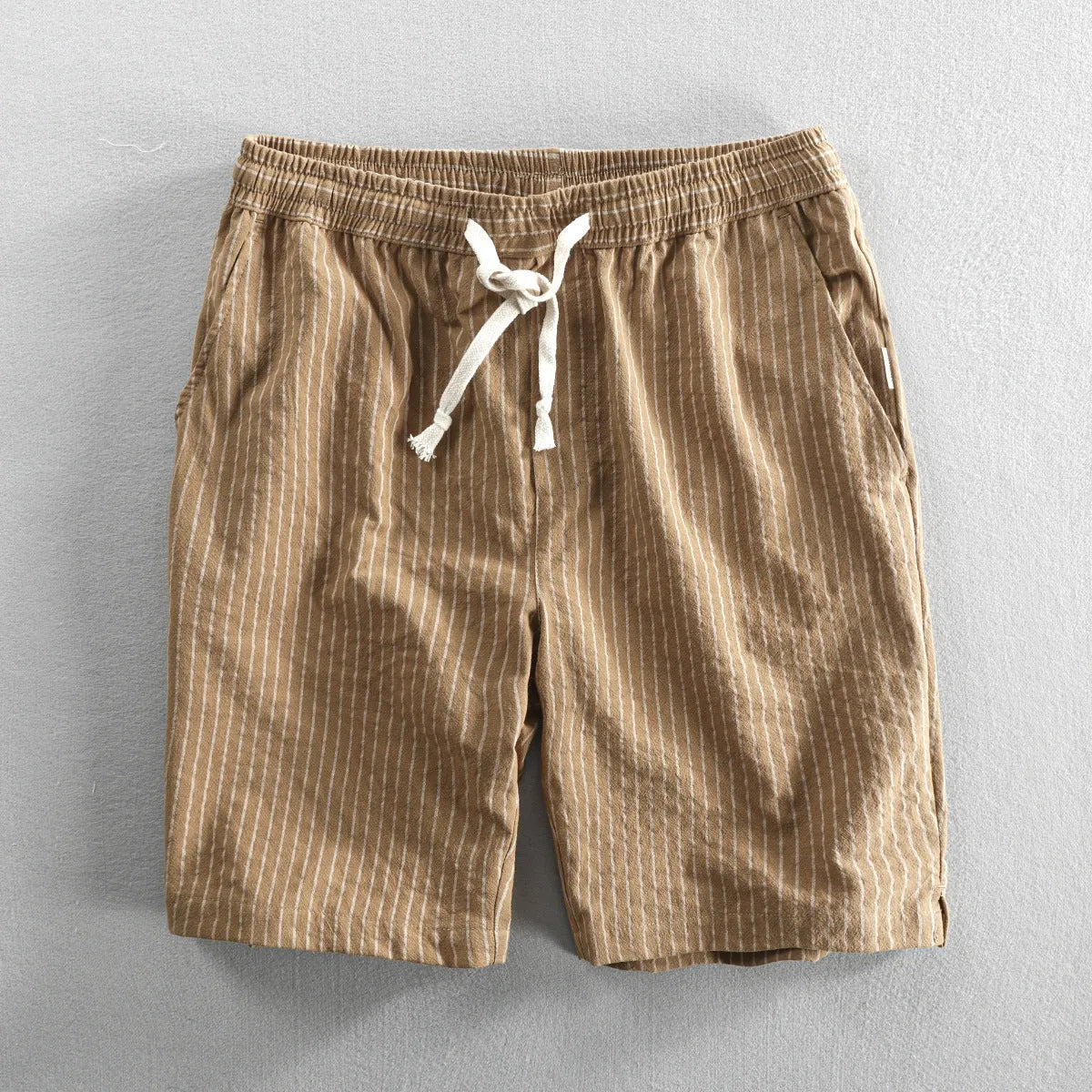 Man wearing black and white striped loose-fit casual cotton shorts with a mid waist.