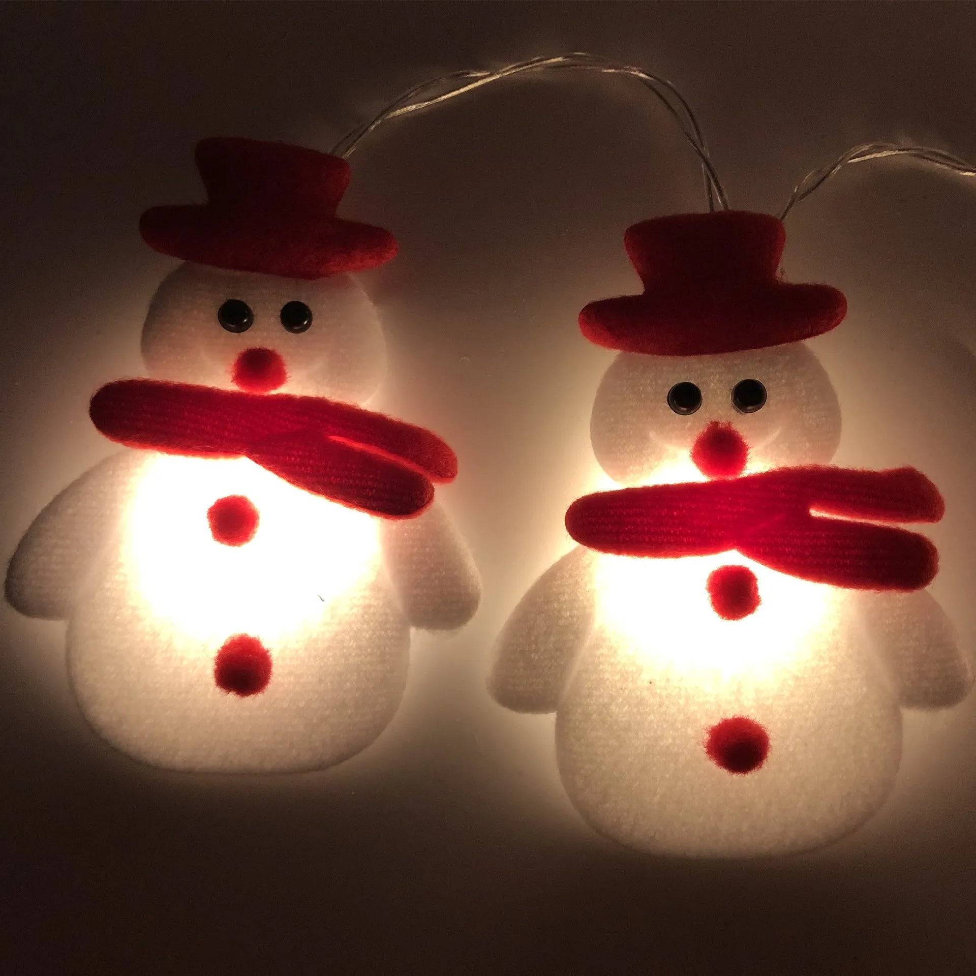 Warm white LED Christmas string lights with Snowman decorative figures on a green garland.