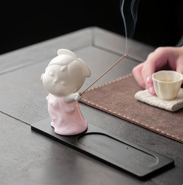 Ceramic cute female court attendant figurine incense burner decoration on a surface.