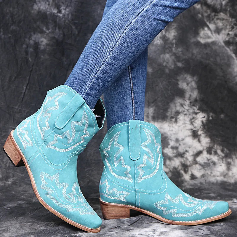 Women's blue embroidered cowboy ankle boots with a low wedge heel and pointed toe.