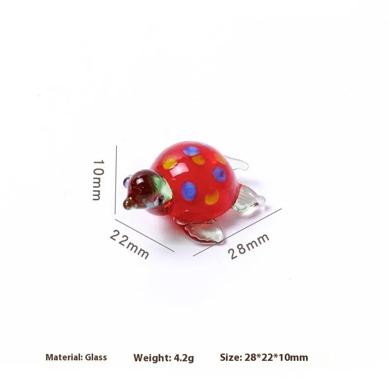 Geometric glass turtle ornament with a blue head and blue shell on a wooden desktop.