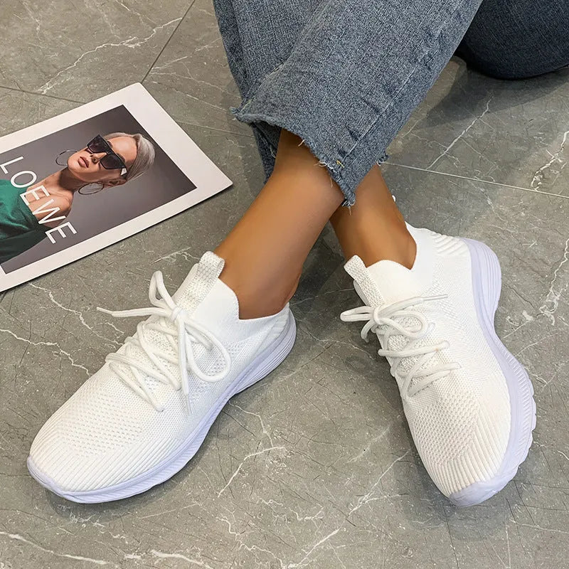 Women's low-top running shoes in Creamy White with mesh detailing and a flat rubber sole.