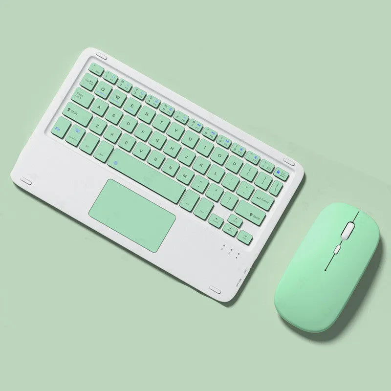 Pink Bluetooth touch keyboard and rechargeable wireless mouse on a desk next to a tablet.