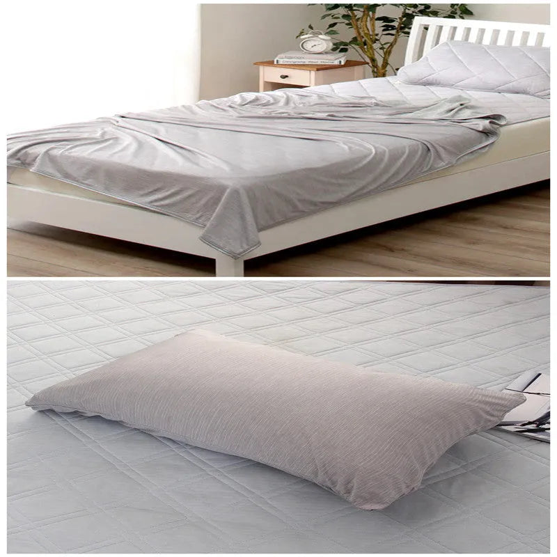 A blue polyester cooling blanket with Q-Max 0.4 technology laid on a bed.