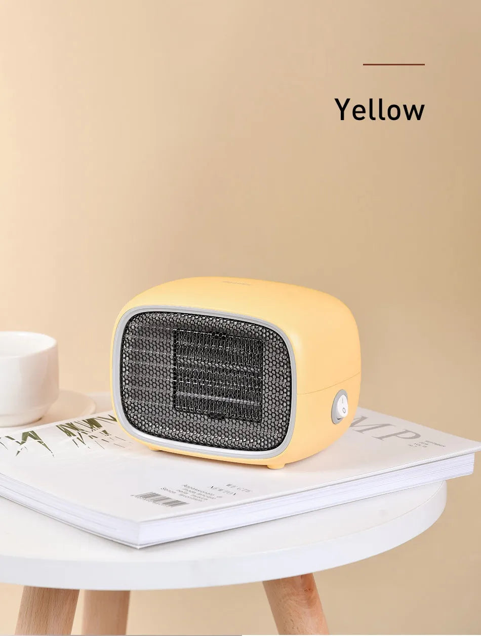 Compact green mini ceramic heater with metal mesh front on a wooden desk