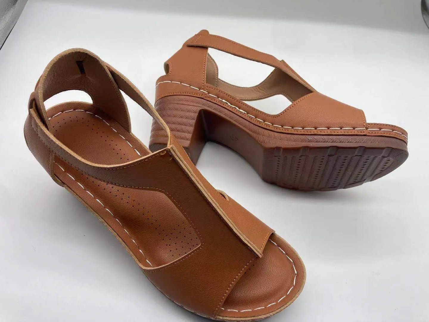 Women's peep toe wedge sandals with buckle detail, low heel, on a white background.