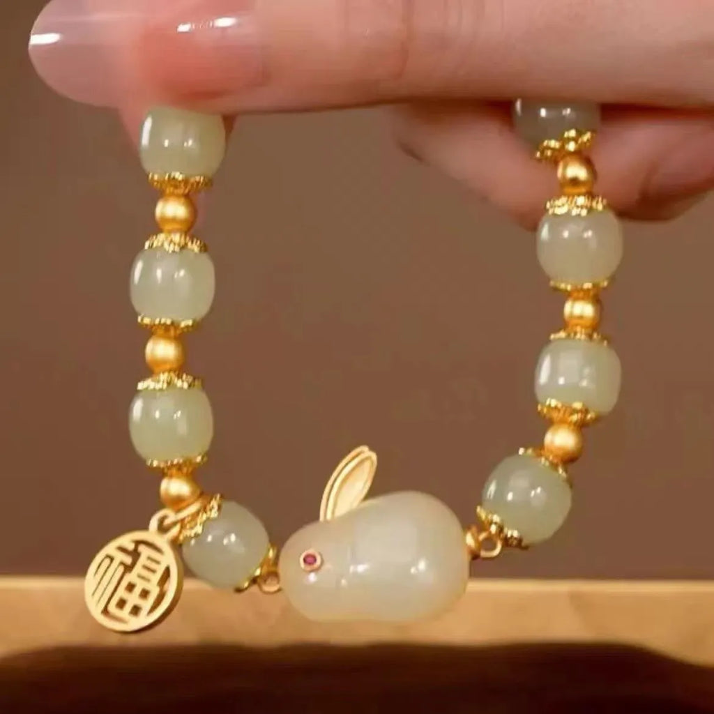 Green jade hare charm bracelet with black hand band showing lily engravings and fu character detail