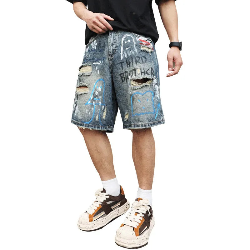 Men's blue ripped denim shorts with graffiti design and straight leg.