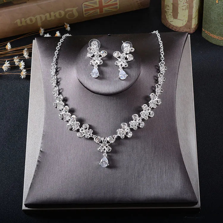 White rhinestone butterfly pendant necklace and matching pierced drop earrings set on white background