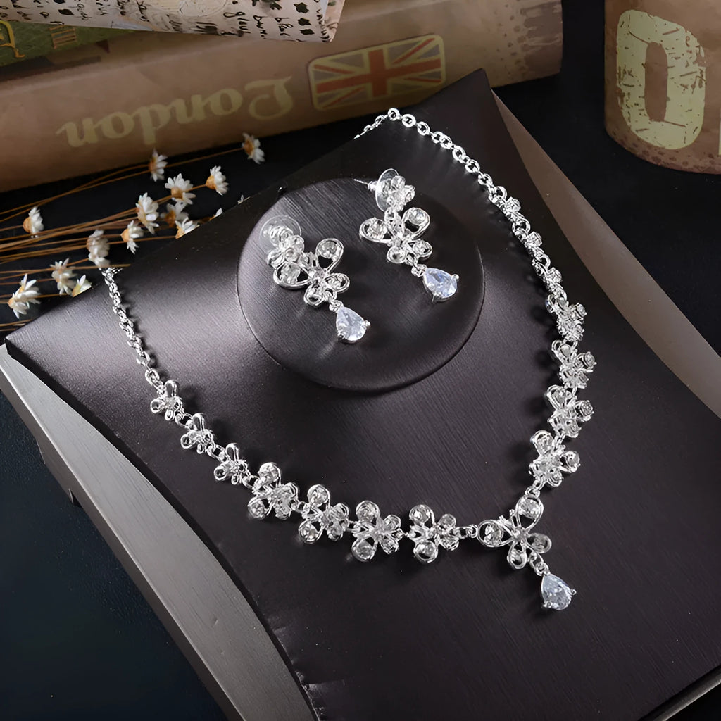 White rhinestone butterfly pendant necklace and matching pierced drop earrings set on white background