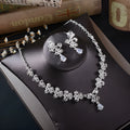 White rhinestone butterfly pendant necklace and matching pierced drop earrings set on white background